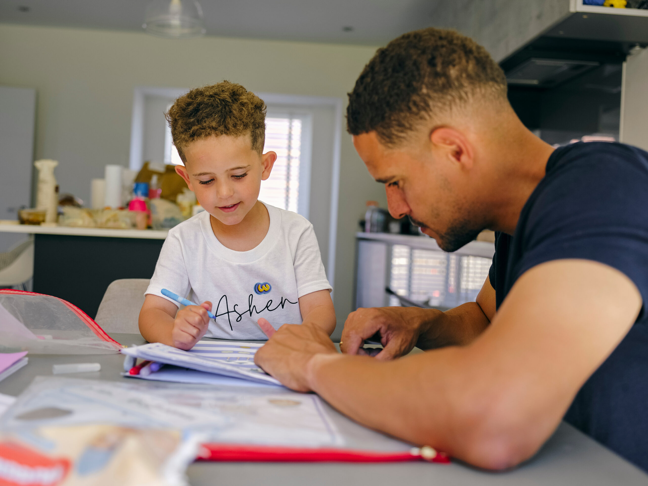 Enfance, un papa et son fils font des devoirs